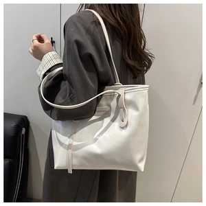 Close-up of white oversized tote bag with Fashion & Bags metal plaque detail