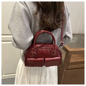 Detail of dark red vintage PU leather bowling bag featuring dual front flap pockets