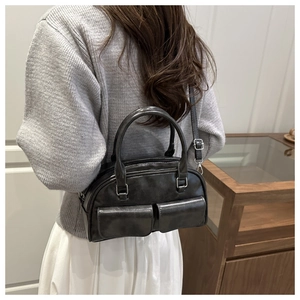 Close-up of black bowling bag with glossy texture and side pockets worn by model
