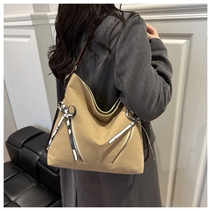 Side view of large khaki canvas tote bag with striped ribbon and brown shoulder strap