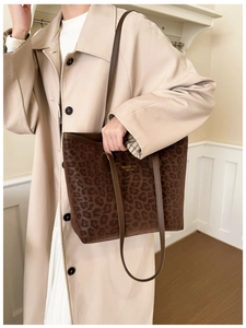 Close-up of leopard print tote bag with gold lettering and slim shoulder straps