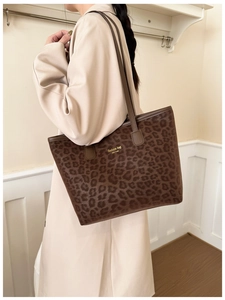 Detailed view of leopard print tote bag with gold lettering and slim shoulder straps