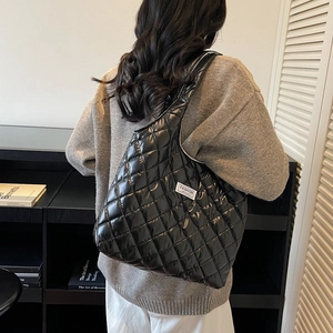 Women's black quilted nylon puffer tote bag with high-gloss finish and spacious interior