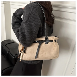 Detail of khaki frosted crossbody bag with wooden beads and black leather strap