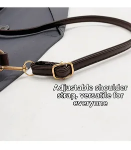 Detail of adjustable dark brown faux leather shoulder strap with gold metal buckle