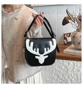 Détail de l'écusson tête de cerf blanc sur un sac à bandoulière carré noir