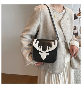 Gros plan du sac bandoulière renne noir et blanc porté par un mannequin élégant