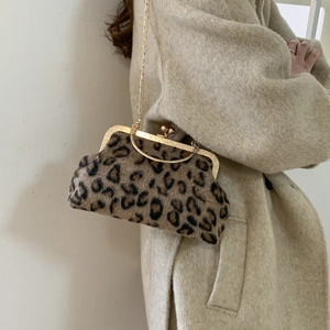 Fashion leopard print crossbody bag with gold chain strap shown on a beige wool coat