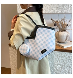 Detail of blue and white checkered bucket bag with mini round coin purse and black straps