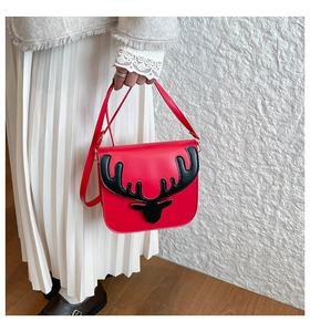 Détail du sac bandoulière rouge festif avec patch de bois de renne noir sur le rabat