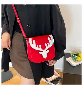 Vue détaillée du sac bandoulière en cuir rouge avec un motif de renne blanc sur le rabat
