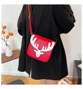 Détail du sac rouge avec applique de bois de renne blanc porté par un mannequin au café
