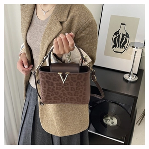 Détail du sac boîte vintage en daim léopard marron avec fermoir métallique doré en forme de V