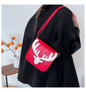 Détail du sac bandoulière rouge en cuir PU avec applique de renne blanc sur modèle