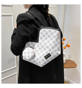 Detail of checkered shoulder tote bag with a matching round coin purse and logo tag