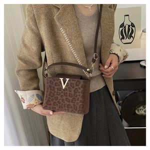 Close-up of leopard print texture and gold V logo on a stylish crossbody bag