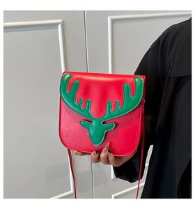 Close-up of red Christmas crossbody bag with green reindeer head and leather strap