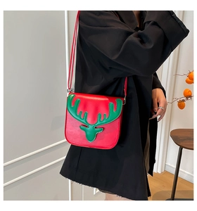 Détail du sac bandoulière en PU rouge avec applique renne vert sur l'épaule du modèle