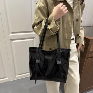 Minimalist black glossy patent leather tote bag with long handles and fashion logo patch