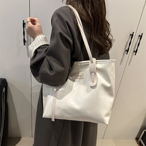 Minimalist beige glossy leather tote bag with long handles for stylish office commuting