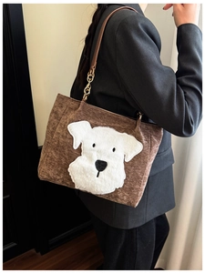 Detail of brown corduroy tote bag with white fluffy dog patch and gold chain strap