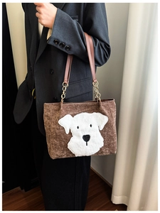 Detail of vintage corduroy tote bag with plush puppy embroidery and gold chain strap