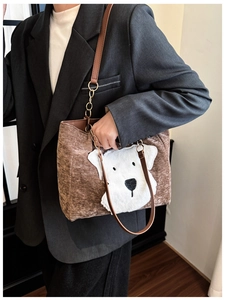 Brown corduroy tote bag detail featuring a plush puppy patch and leather strap