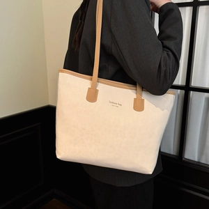 Chic cream tote bag with brown straps and New York print shown on a model
