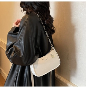 Detail of white lychee leather texture on crescent bag with gold chain strap