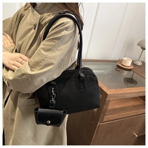 Detail view of the black faux suede tote with a matching mini pouch and metal clasp