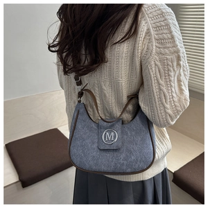 Gros plan sur le logo M argenté et les finitions en cuir du sac vintage