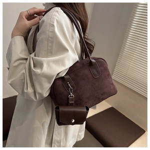 Macro detail of coffee brown suede bowling bag with matching mini charm and soft texture