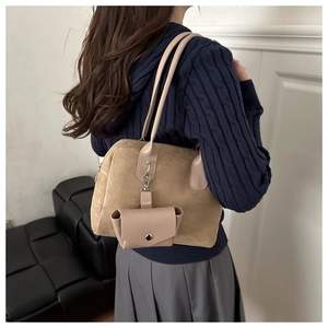 Detail of khaki suede shoulder bag with detachable mini leather pouch and dual straps