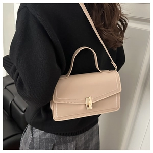 Detail of beige faux leather crossbody bag with square gold buckle and stitch trim