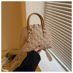 Nahaufnahme der beigen Muscheltasche mit Waffelmuster und Doppelreißverschluss-Detail