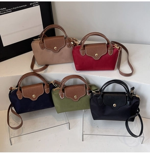 Five assorted mini nylon crossbody bags with leather flaps in various colors on display
