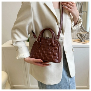 Detailansicht der tiefbraunen Muscheltasche mit 3D-Karomuster und goldenen Reißverschlüssen