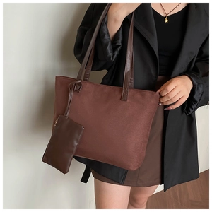 Brown faux suede tote bag with matching mini pouch shown on shoulder of a model