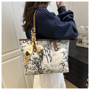Detail of bamboo ink print tote bag with brown leather handles and decorative scarf wrap