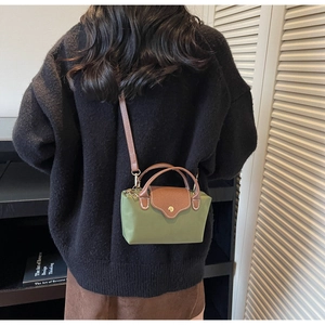 Olive green nylon mini crossbody bag shown on model to demonstrate compact size and fit