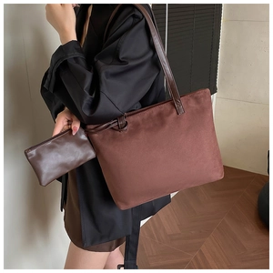 Close-up of deep brown suede tote bag and matching pouch with fine matte texture