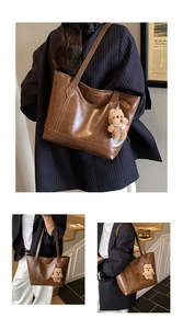 Detail of vintage brown tote bag with fashion embossing and plush bear charm accent