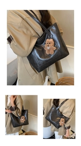 Detail of black faux leather tote bag with a cute brown teddy bear plush charm