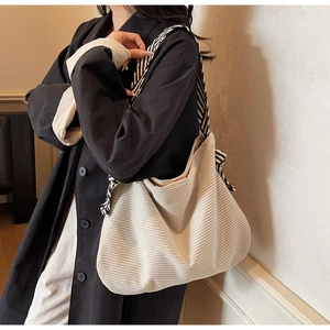 Detail of corduroy tote bag with striped shoulder strap for urban minimalist fashion