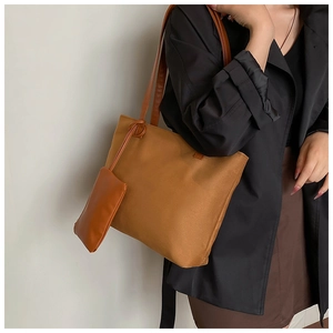 Brown leather tote bag and detachable mini pouch set worn on shoulder for commuting