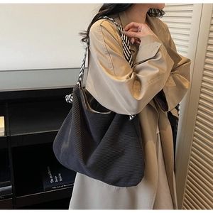 Detail of black corduroy tote bag with stylish black and white geometric wide strap