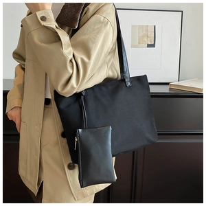 Detail of black suede tote bag with matching zippered pouch and wide shoulder strap