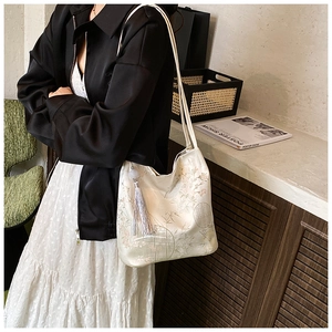 Detail of elegant Chinese style tote bag featuring floral embroidery and purple tassel