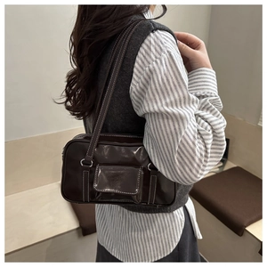 Detail view of large brown oil-wax leather hobo bag with contrast white stitching