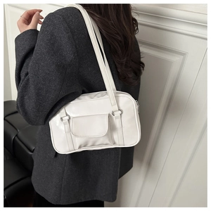 Detailed side view of a minimalist white PU leather shoulder bag with decorative pocket